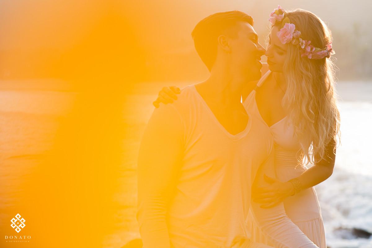 Um beijo dos noivos na praia do guaruja, uma imagem amarelada da um ar de romantismo.