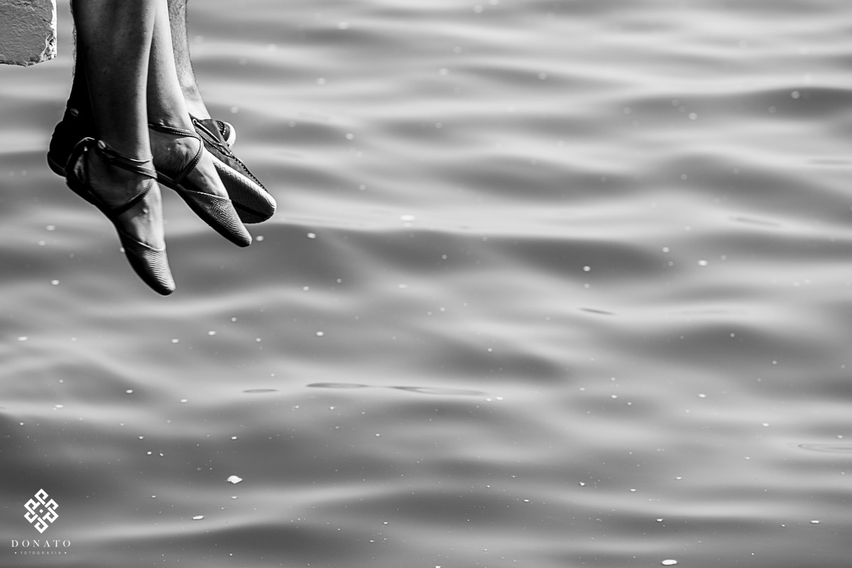 detalhes dos pés dos noivos, a agua abaixo ondulando deixa imagem perfeita.