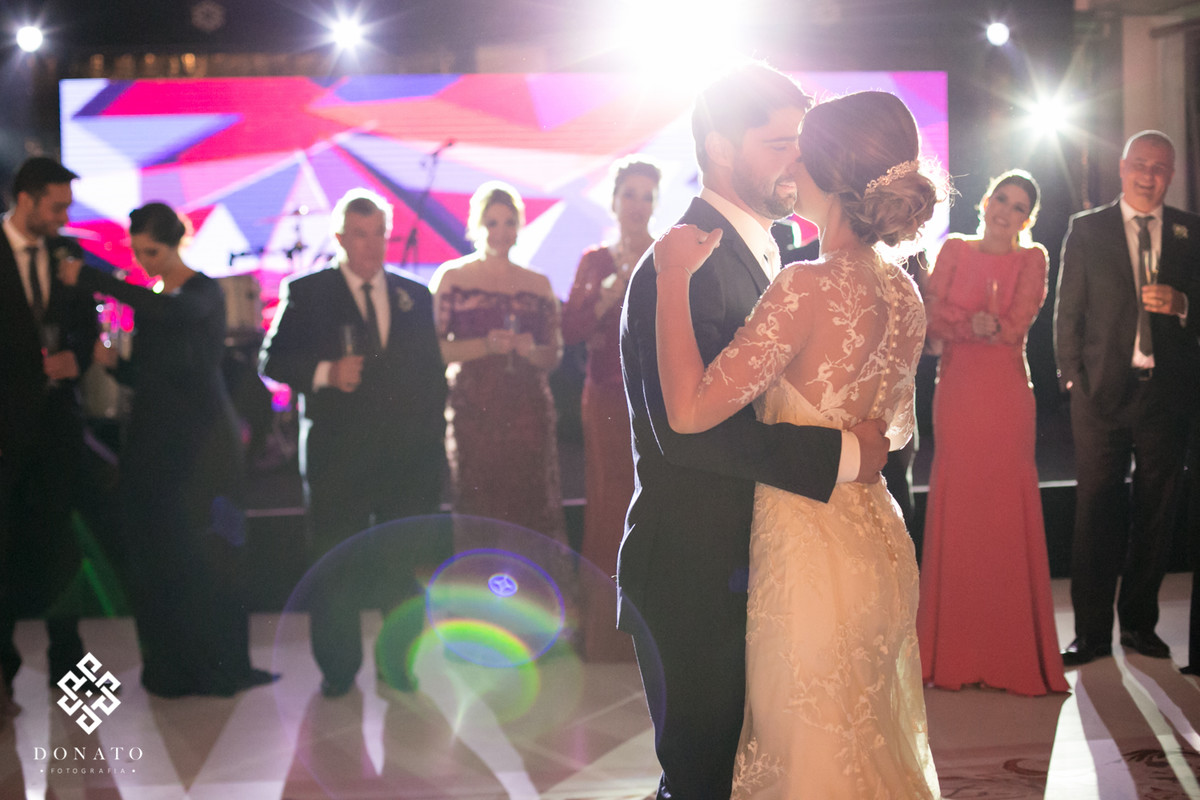 A primeira dança do casal, ao fundo os padrinhos alegres e felizes.