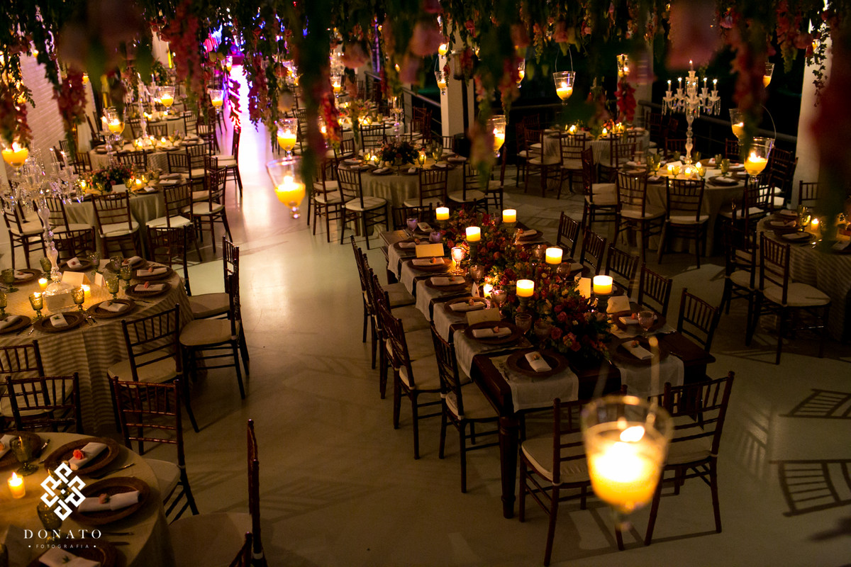 Imagem do alto de todo o salão, as velas acesas da um clima todo romântico ao ambiente.