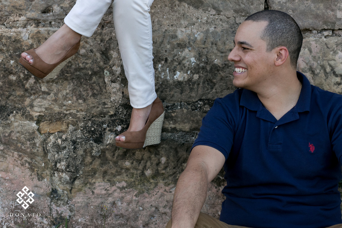 foto dos pes da noiva, e o noivo olhando para ele dando uma risada muito divertida.