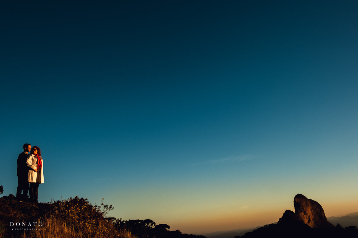 Fotos em Campos do Jordão, com casal no por do sol, com montanha atrás.