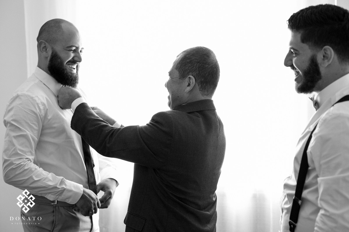 o pai e o irmão ajudam o noivo douglas se arrumar, na preparação para a cerimonia.