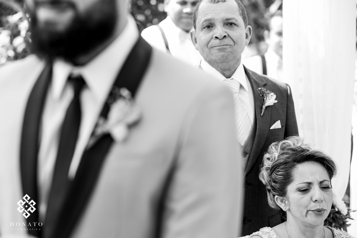 Pai e mãe do noivo se emocionam ao ver o filho se casando.