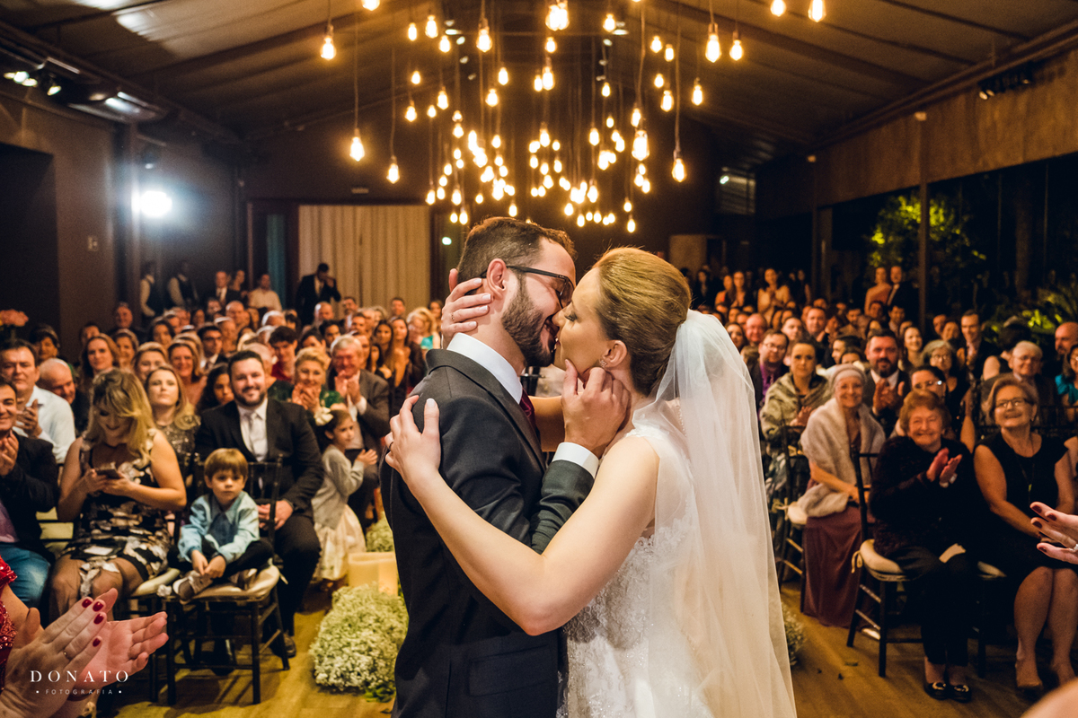 Cerimonia realizada na casa traffo em sao paulo a noite, beijo dos noivos no altar.