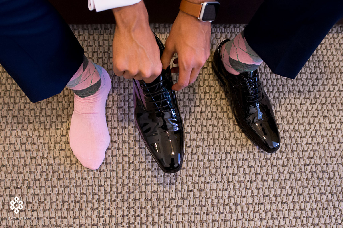 detalhe do sapato e meias do noivo, a meia cor de rosa da todo um charme e modernismo a foto.