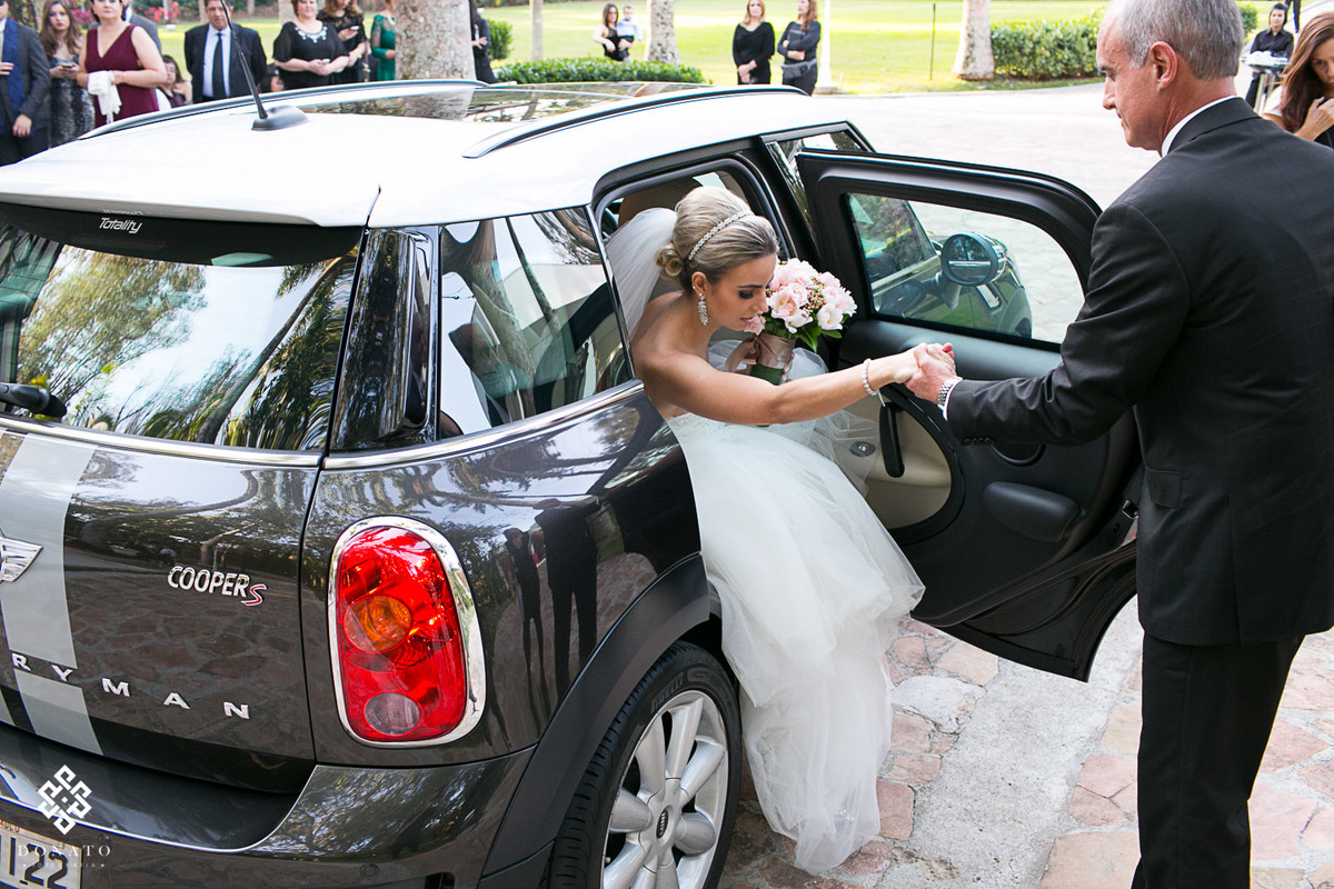 pai ajuda a noiva sair do mini coupe, para entrar na cerimonia.