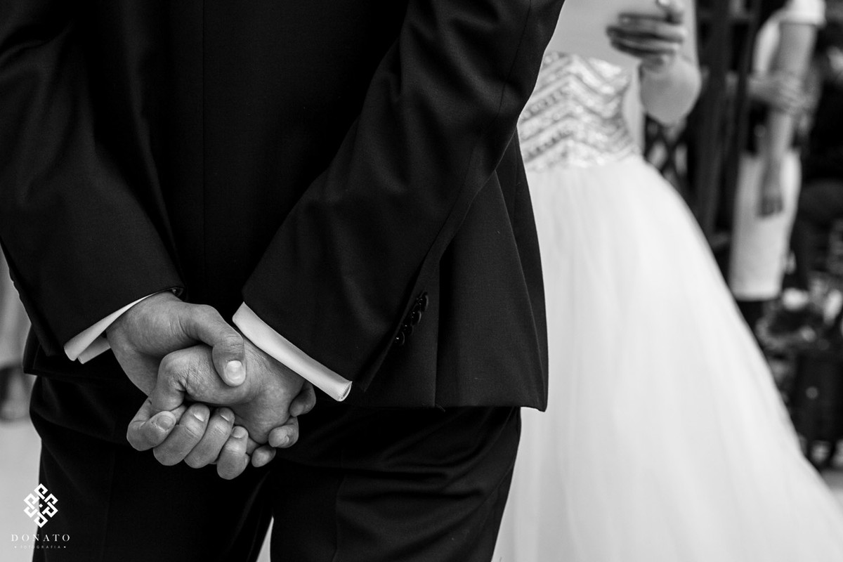 detalhe das mãos do noivo fechada e para trás, dando o sinal que esta tenso e nervoso.