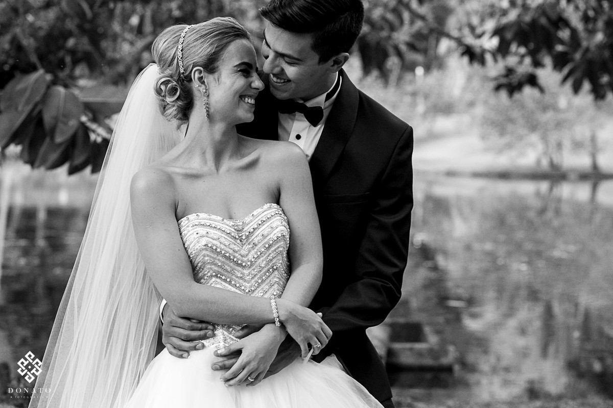 noivos namoram no jardim, bem abraçadinhos, foto esta em branco e preto.