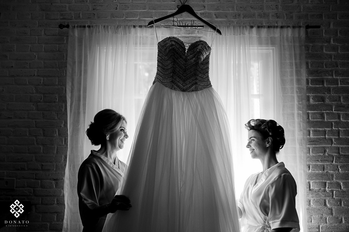 noiva com a mãe, olham os ultimos detalhes do vestido.