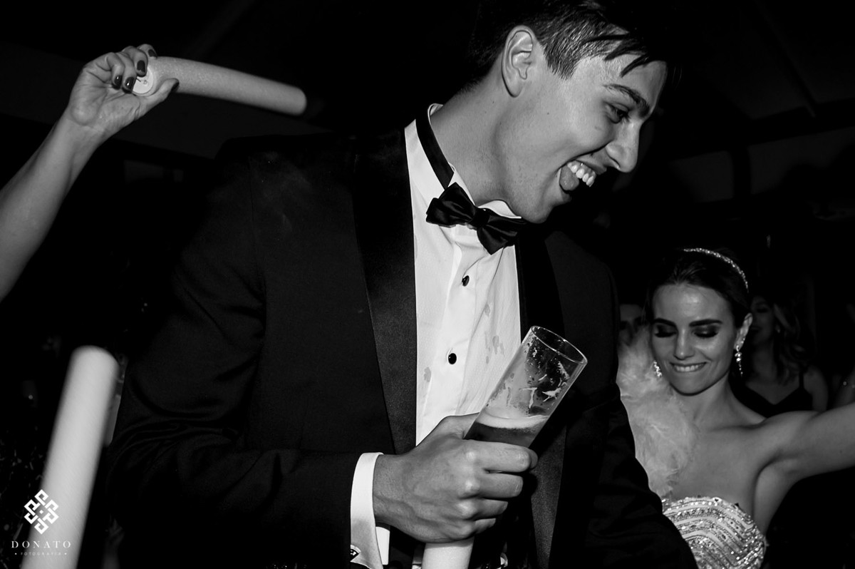 noivo dança com um copo de cerveja na mão.