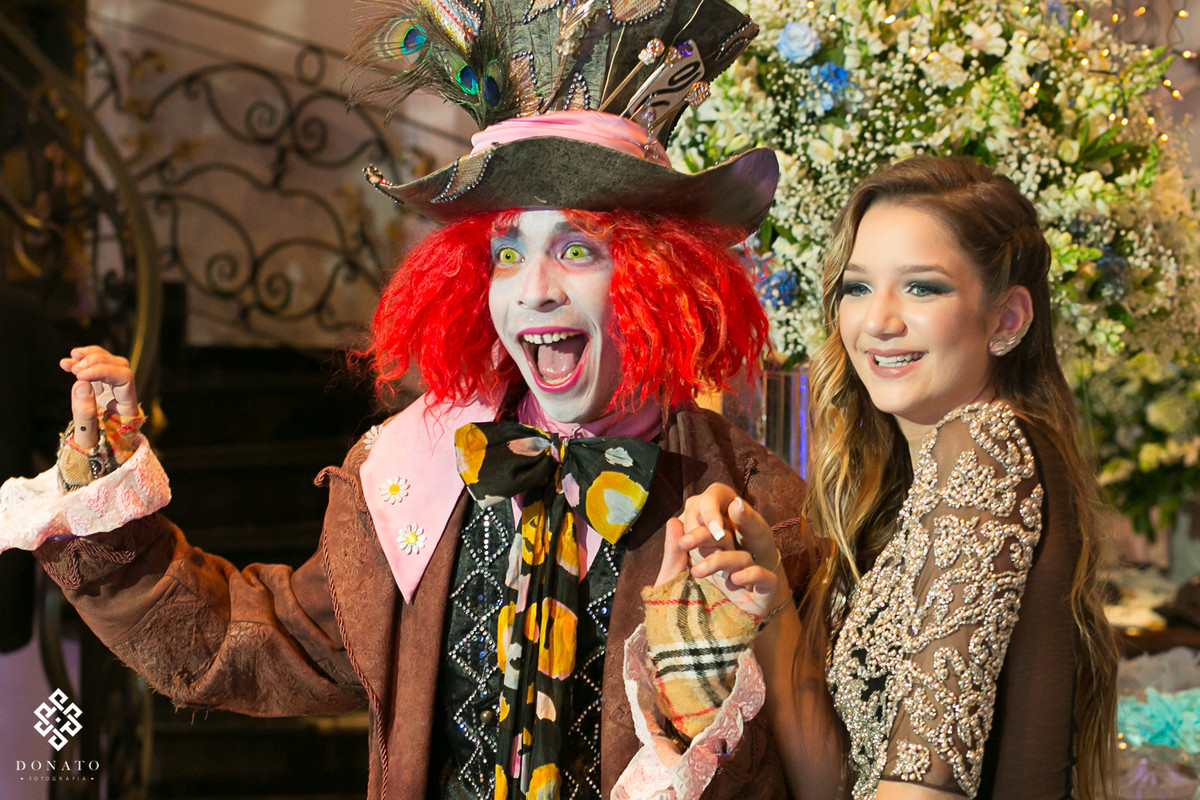 personagem todo colorido junto com a aniversariante se divertem com caretas.