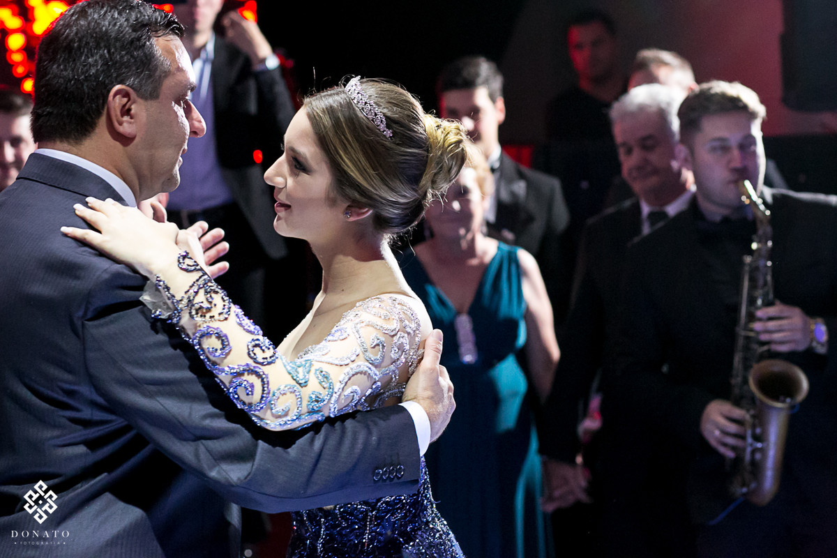 pai dança com a filha, ao fundo avós e tios.