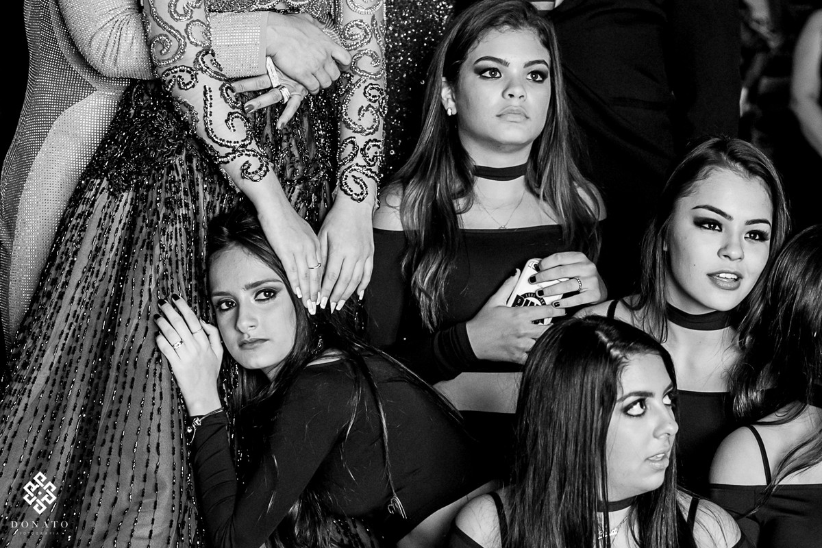 amiga abraça a perna da debutante e se emociona com o vídeo que passa no telão.