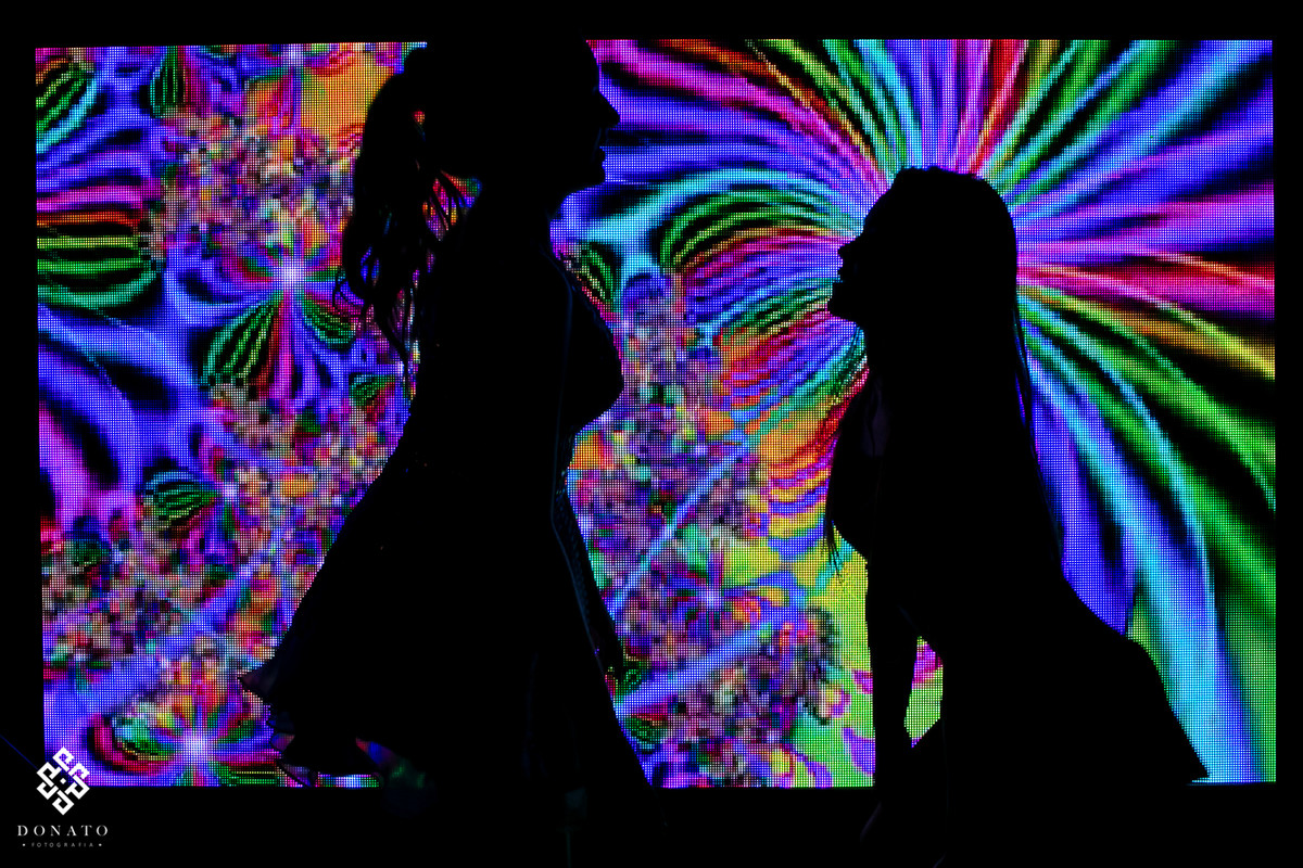 amiga dança com a aniversariante em frente ao telão.