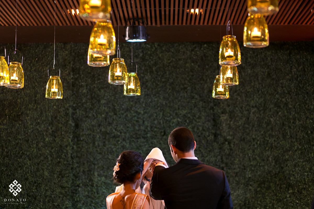 Visão de tr;ás do altar, na benção das alianças e o teto cheio de luz de velas.