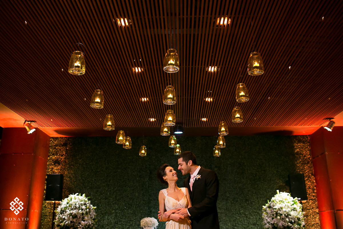 Foto dos noivos posada entre o teto de velas, linda decoração.