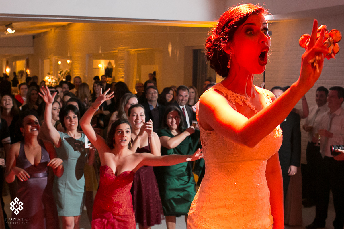 noiva faz careta na hora de jogar o buquet, foto muito divertida.