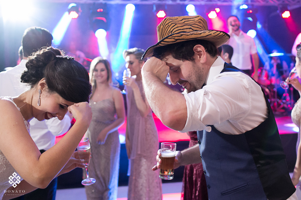 noivo dança com chapéu na pista de dança.