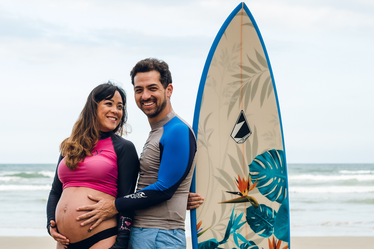 Gestante com prancha de surf