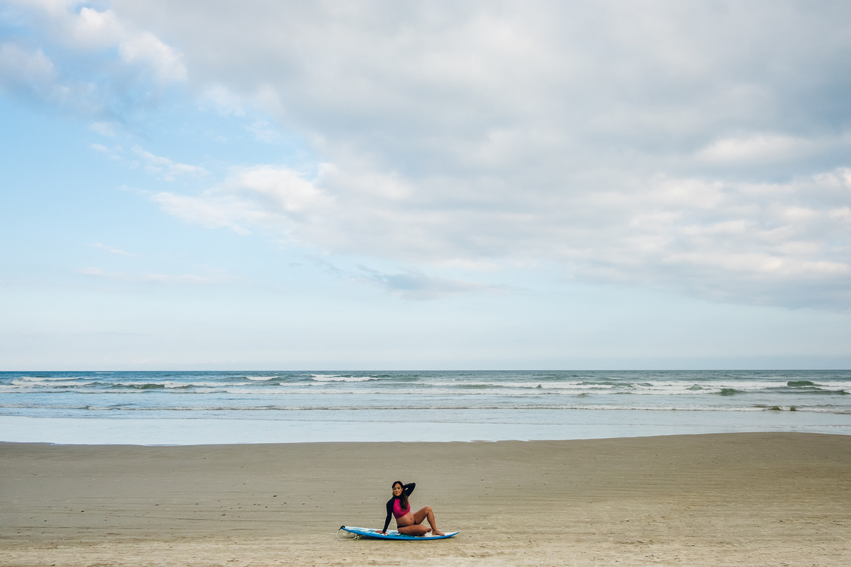 Gestante com prancha de surf