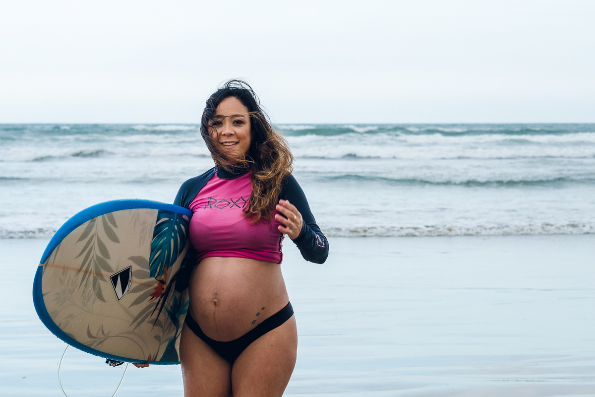 Gestante com prancha de surf