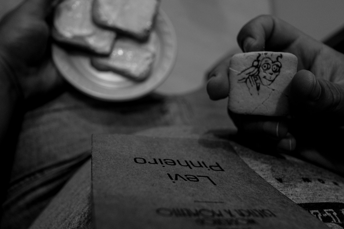 Detalhe da bolacha no café da manhã do Curso de fotografia e detalhe do crachá do aluno.