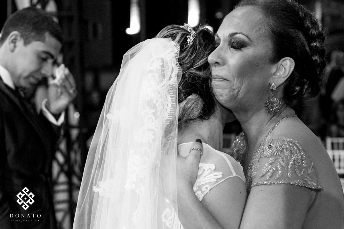 Mae abraça a noiva e se emociona.