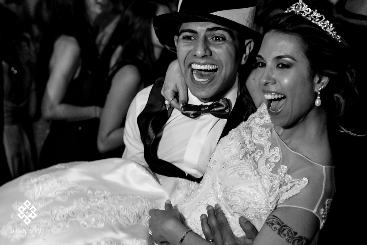 Noivo pega a noiva no colo e se diverte junto com os amigos.