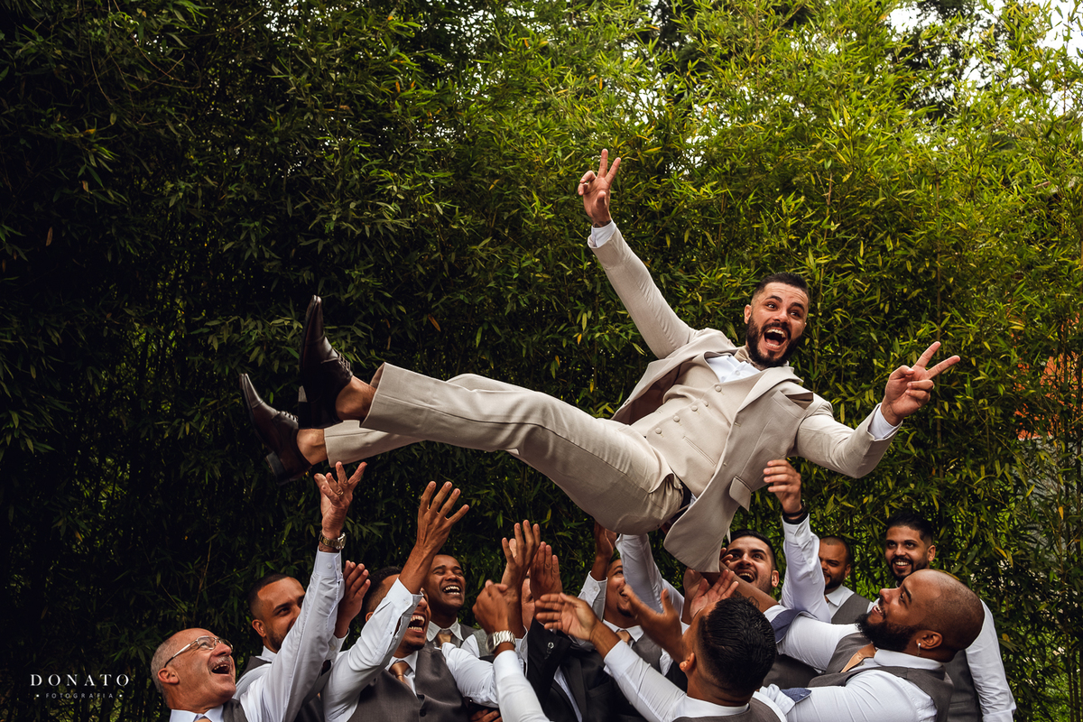 Casamento espaço natureza, cerimonia ao ar livre. Padrinhos jogam o noivo no ar. 