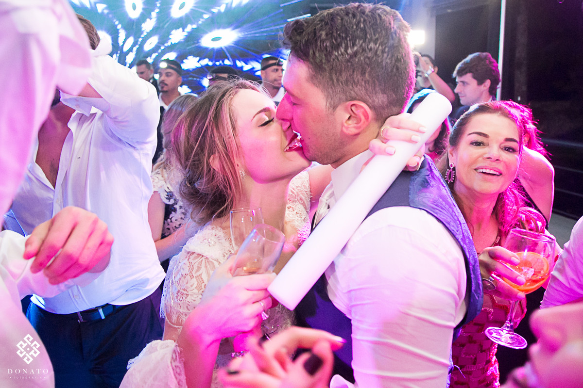 Noiva beija o noivo na pista de dança.