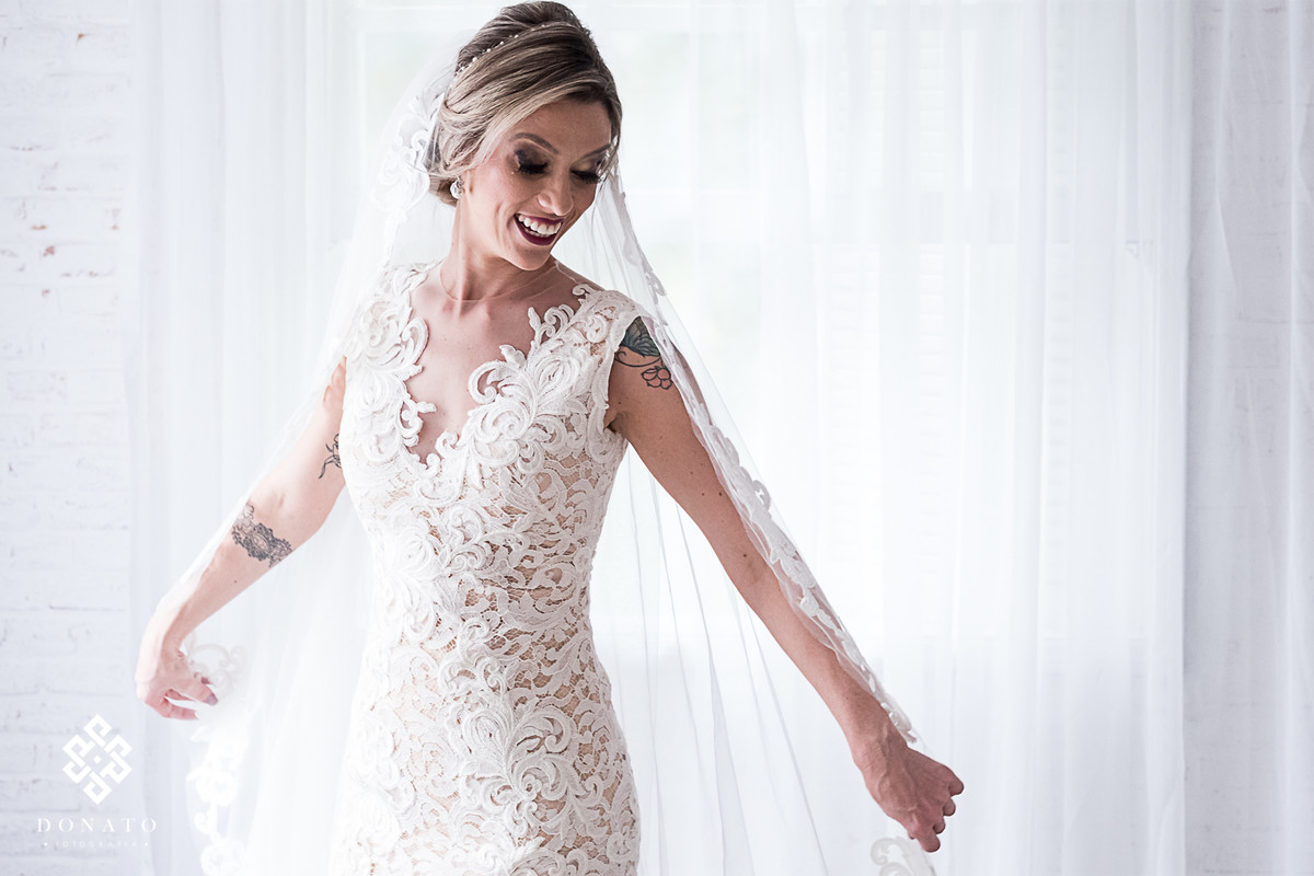 Noiva Carol meche no veu do vestido do Lucas Anderi.