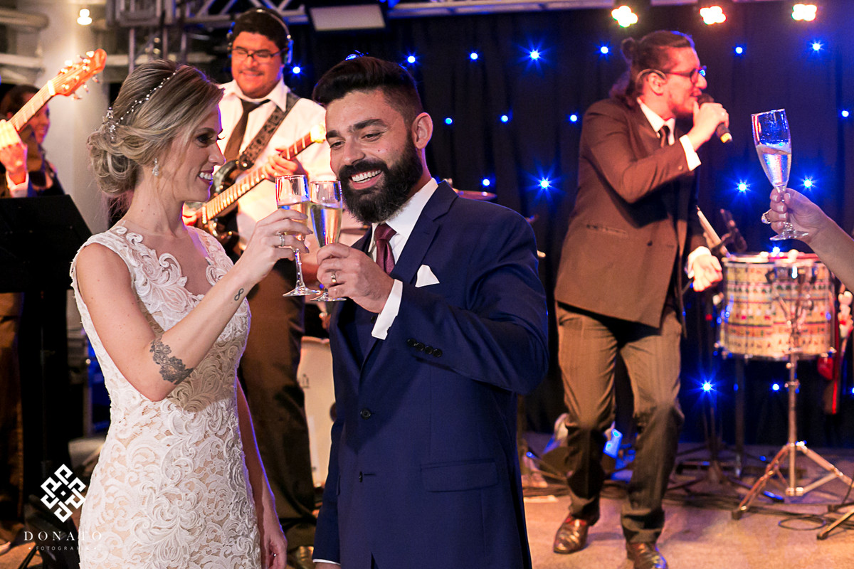 Noivos fazem brinde no imponente salão da Fazenda 7 Lagoas.