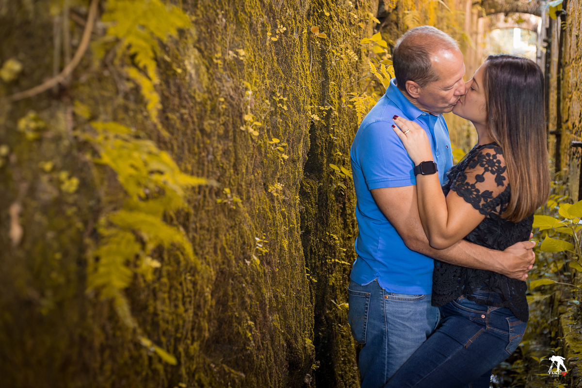 beijo do casal de noivos com parede verde 