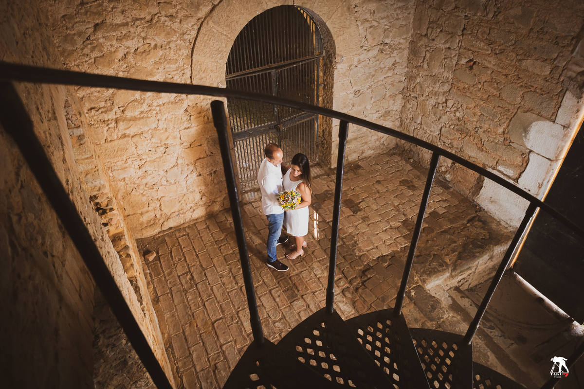 casal entre o corre mão das escadas 