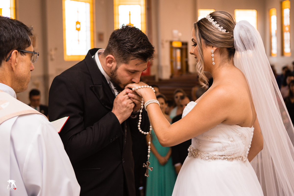noivo beijando aliança de casamento da noiva 
