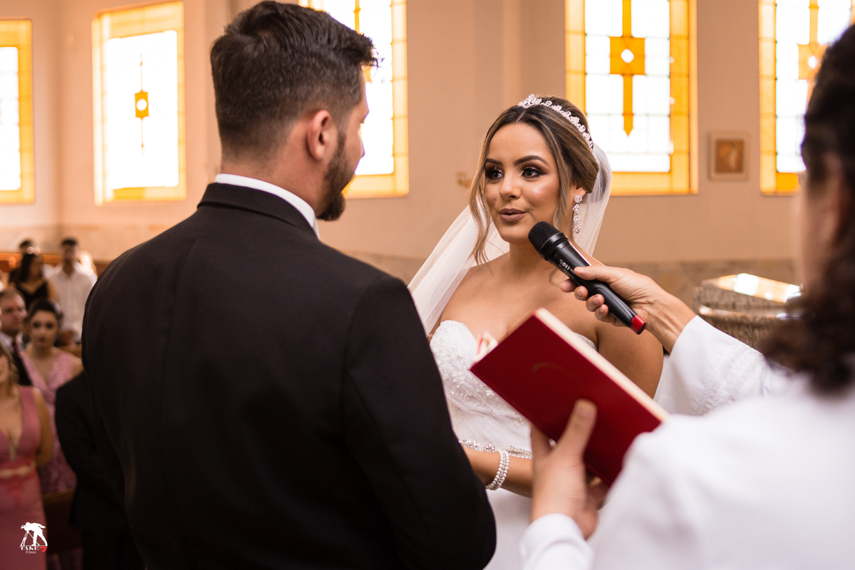 noiva colocando aliança na mão do noivo 