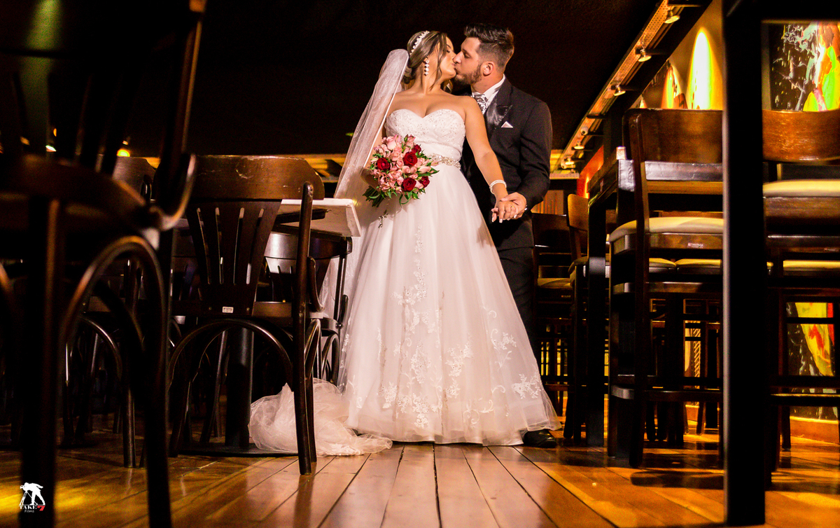 casal de noivos beijando no barzinho