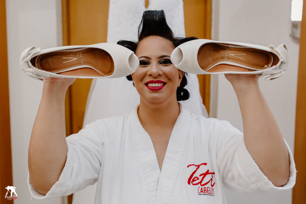 noiva com sapato em mãos 