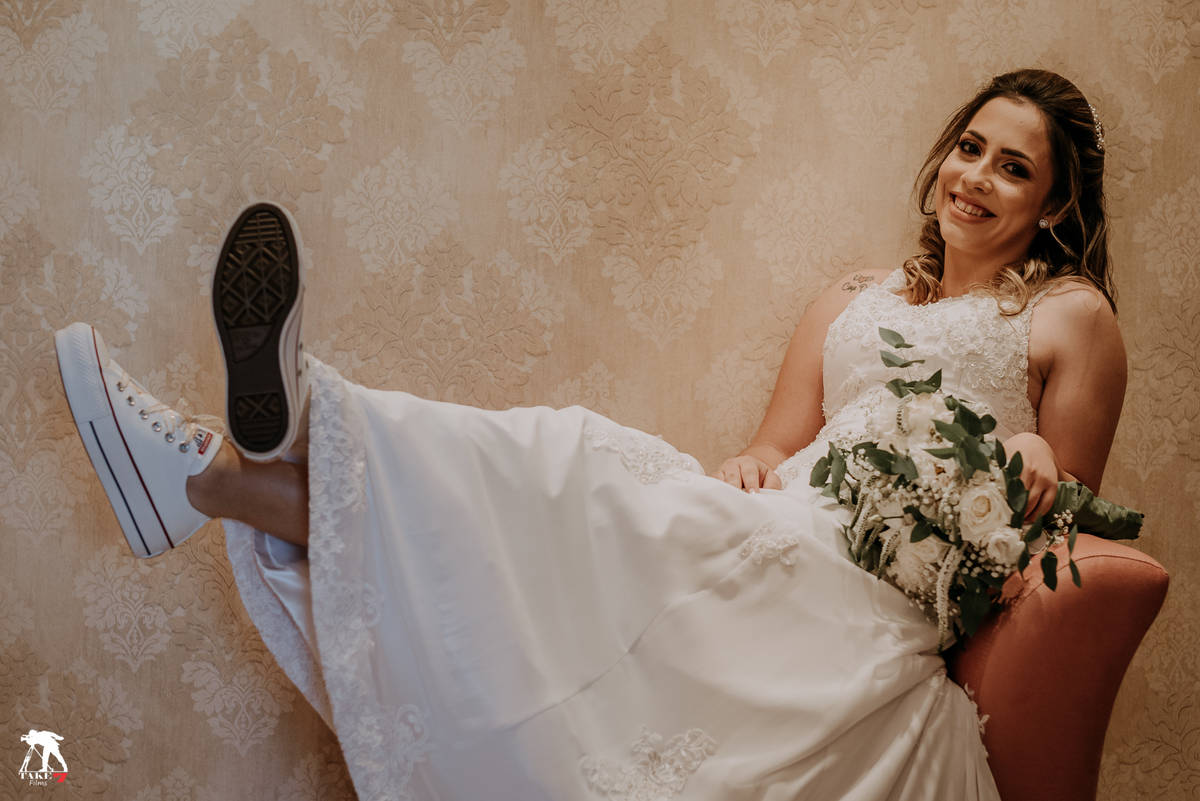 noiva de vestido e tênis sentada no sofá 