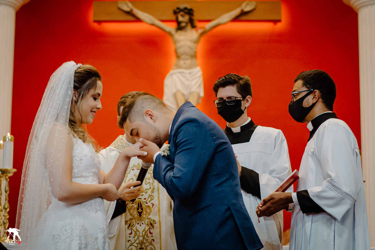 noivo beijando a aliança da noiva