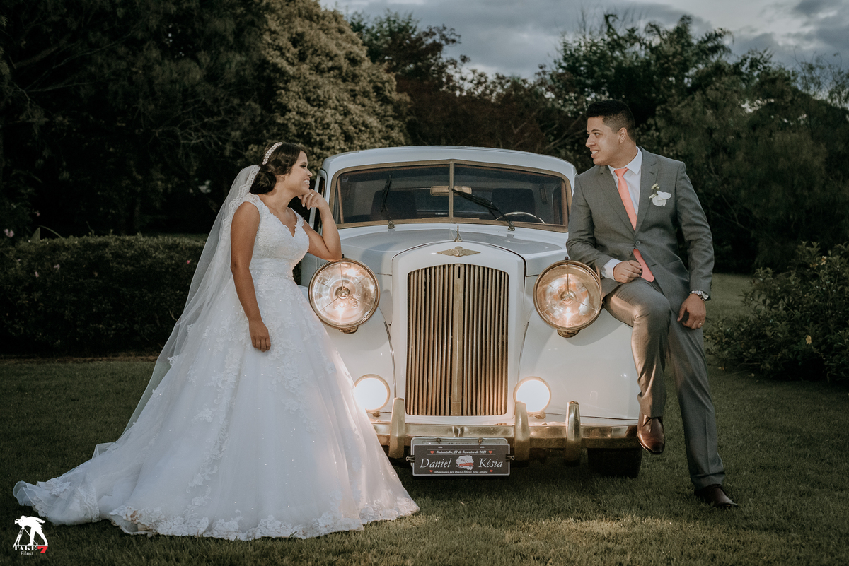 casal de noivos na frente do carro