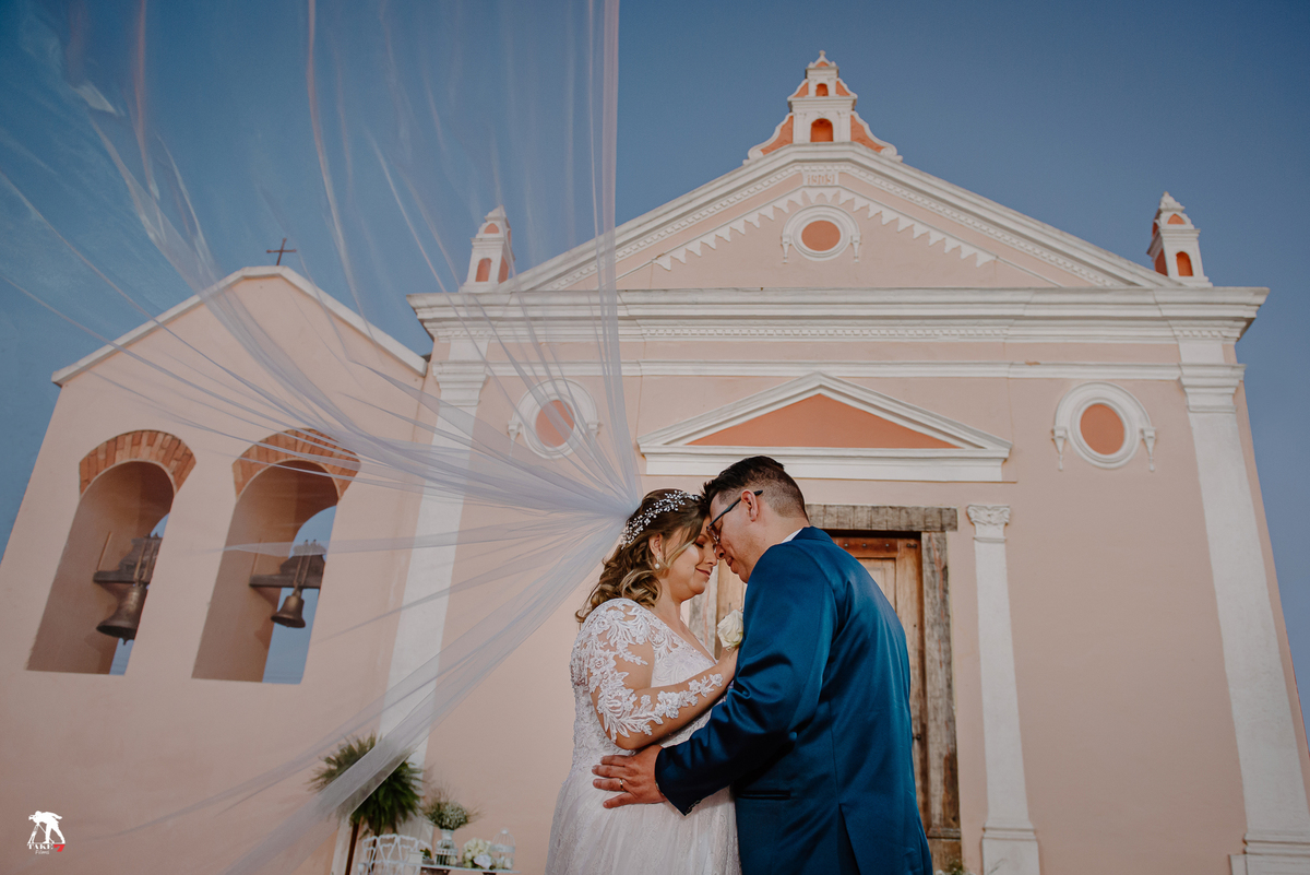 Casal de noivos com véu da noiva 