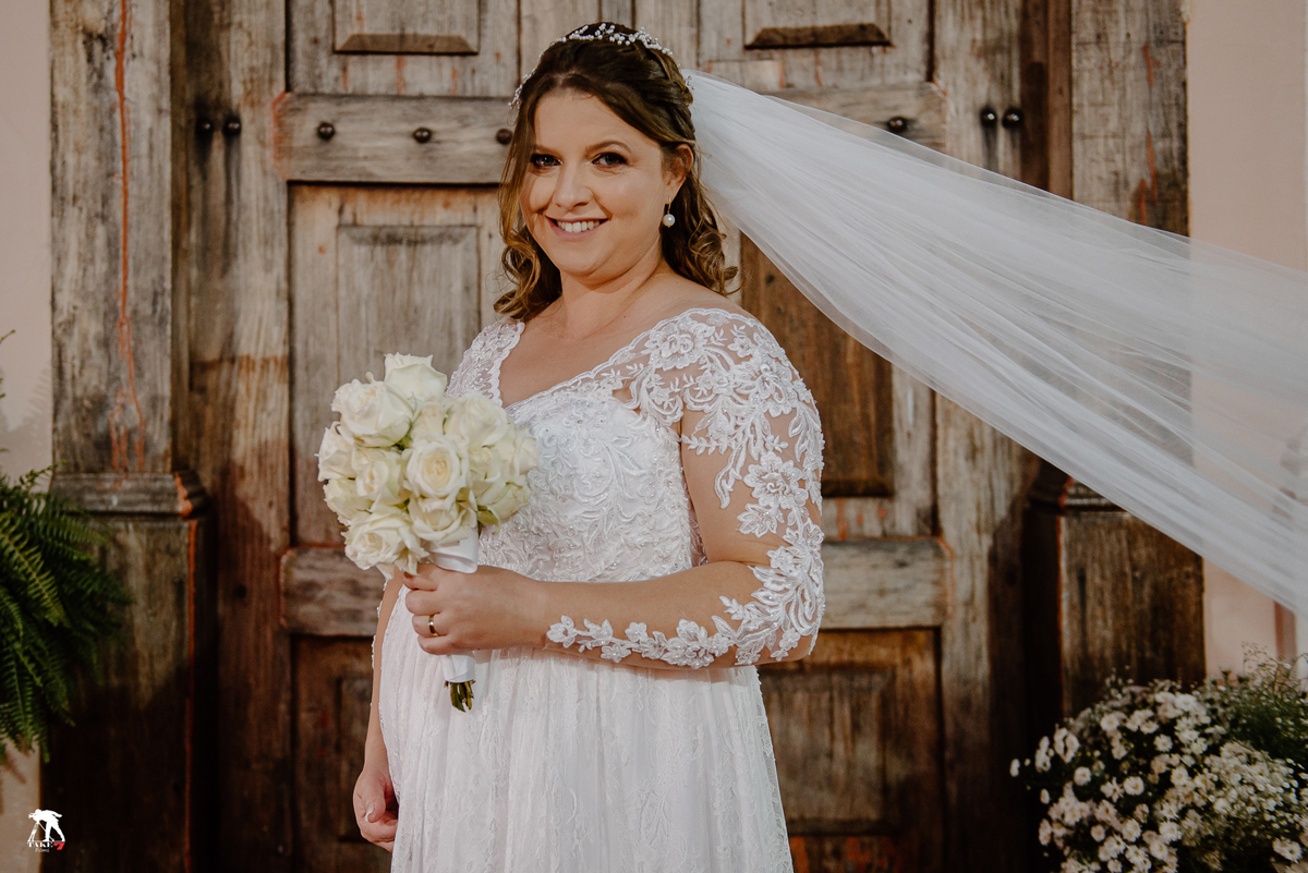 Noiva com buque na frente da igreja