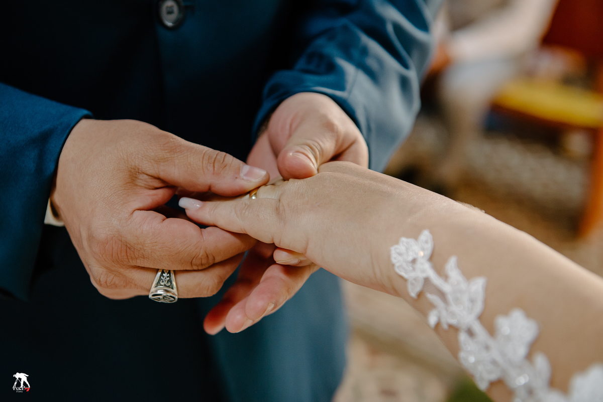 Noivo colocando a aliança na noiva 