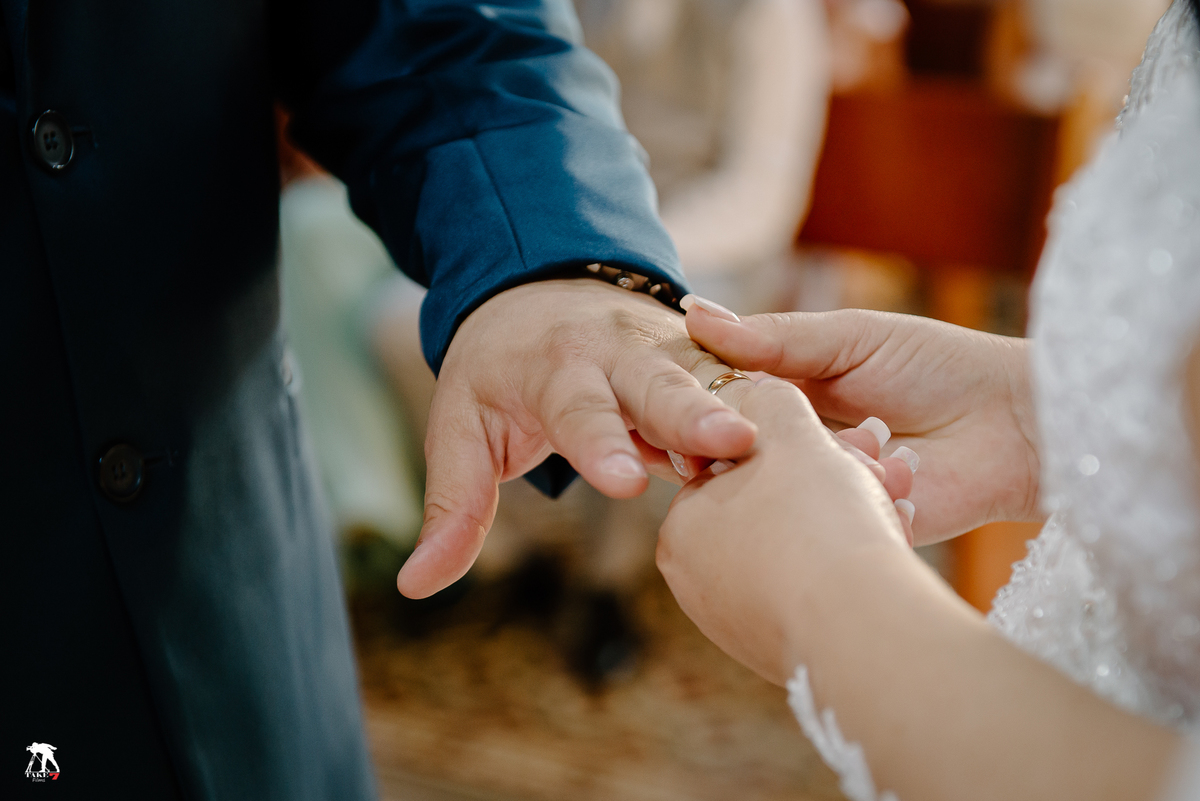 Noiva colocando a aliança na noivo 