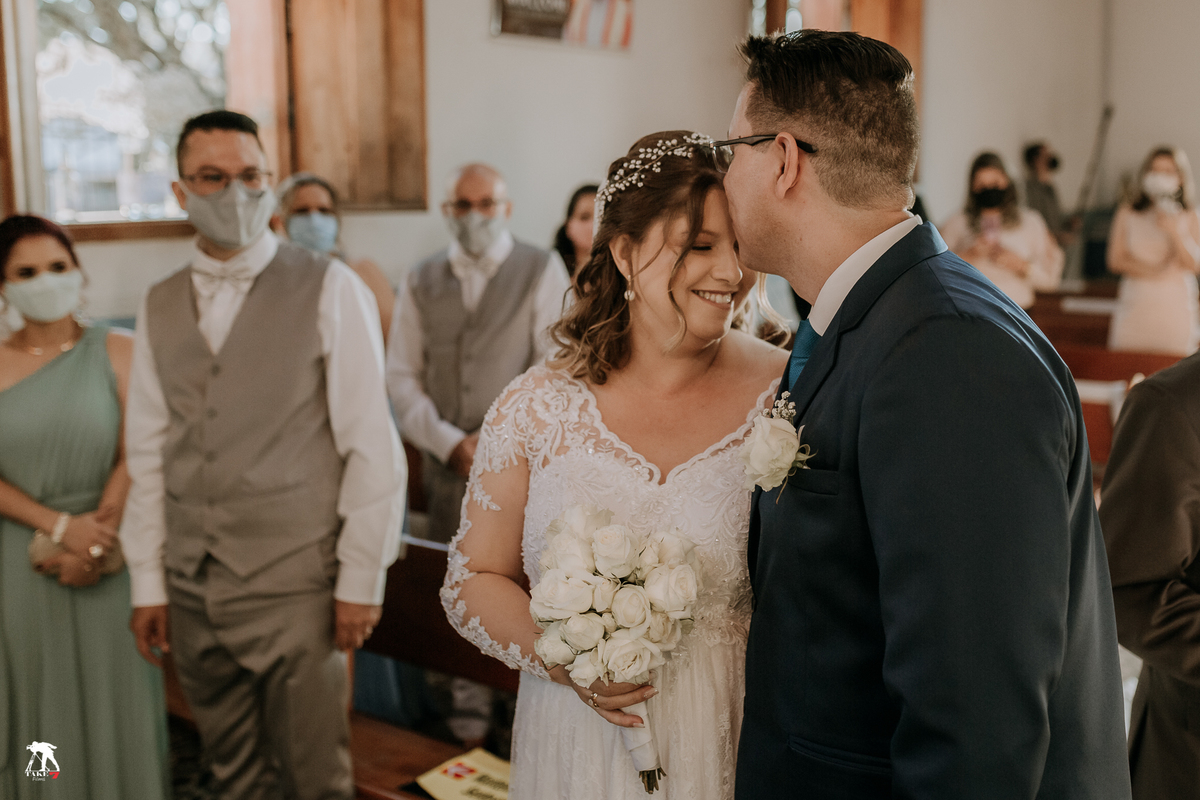 Noivo beijando a testa da noiva 