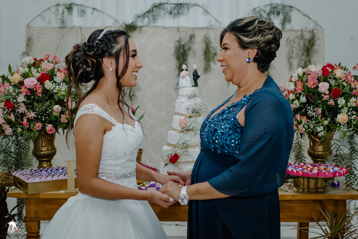 mãe da noiva com a noiva na mesa do bolo 