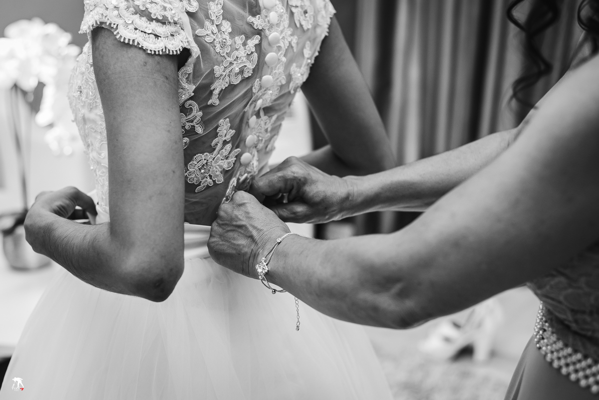 mãe da noiva colocando o vestido 