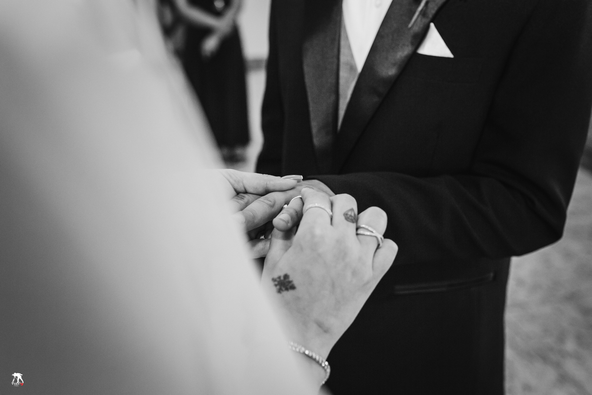 noiva colocando a aliança no dedo do noivo 